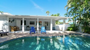 A poolside area with a covered patio, outdoor seating, and a clear view of the pool. - Private Pool, Pets & Beach Days Just Steps Away (Holmes Beach)