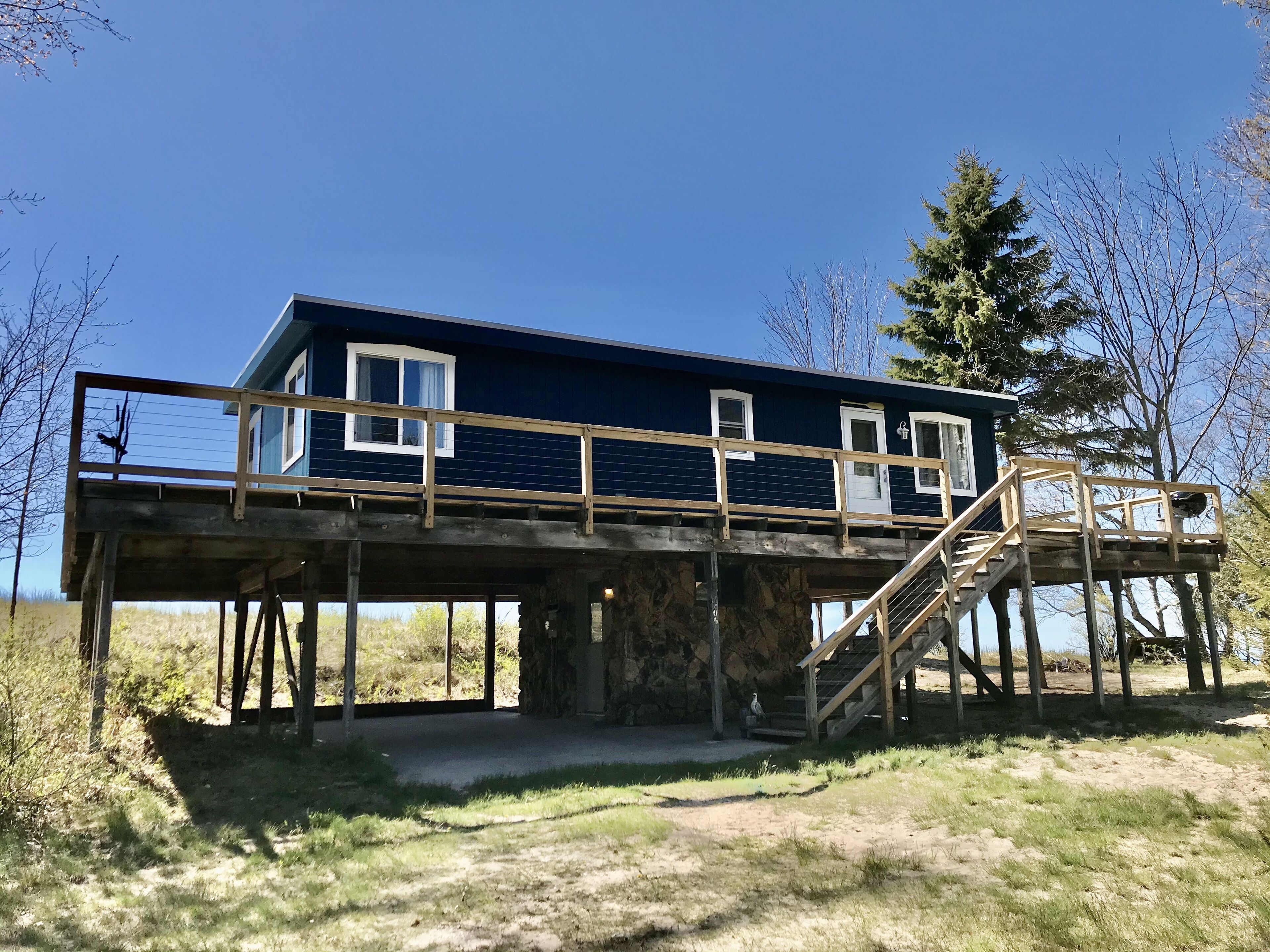 Une maison à deux étages avec un balcon et une terrasse en bois.