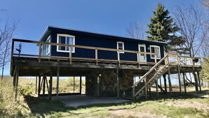 Une maison à deux étages avec un balcon et une terrasse en bois.