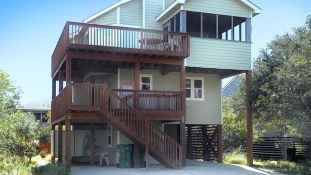 A two-story building with a balcony on the upper floor and a covered outdoor area with a staircase. - OS756- 5 BRs, Private Pool, Hot Tub, Pool Table, Dog Friendly, Comm. Tennis! (Corolla)