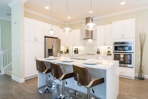 This modern kitchen with stainless appliances and breakfast bar comes fully equipped for any chef to be able to whip up their favorite meal