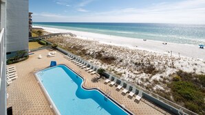 A pool area with a view of the beach and ocean.