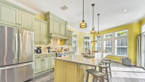 A kitchen with a central island, stainless steel appliances, and pendant lighting. - Beautiful Home Two Houses from the Beach!  Pool, Private Patio, 3 Bedrooms (Holmes Beach)