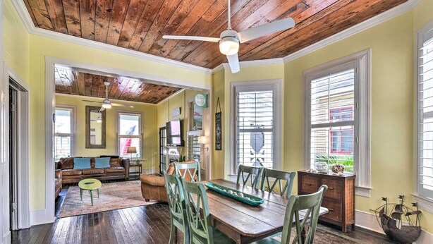 A dining area with a wooden table, chairs, and a ceiling fan. - Walk to Beach! Group-Friendly Galveston Hideaway (Galveston)