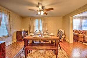 A dining room with a wooden table set for four, a ceiling fan, and a patterned rug. - Whimsical Lancaster Home - 4 Mi to Sight & Sound (Lancaster)