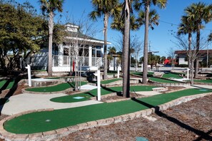 Play a round of golf amidst lush palm trees and a picturesque backdrop.