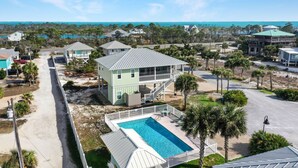 A coastal residential area with a prominent house featuring a balcony and a swimming pool. - Directly Next to Community Pool! Beach view! ~Fried Green Tomatoes (Cape San Blas)