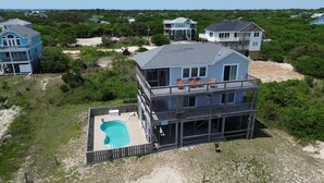 A two-story house with a pool, surrounded by greenery and other houses. - Summer Paws | 3BR 4x4 OBX | Hot Tub | Pets | 4 night stay available for fall (Carova)