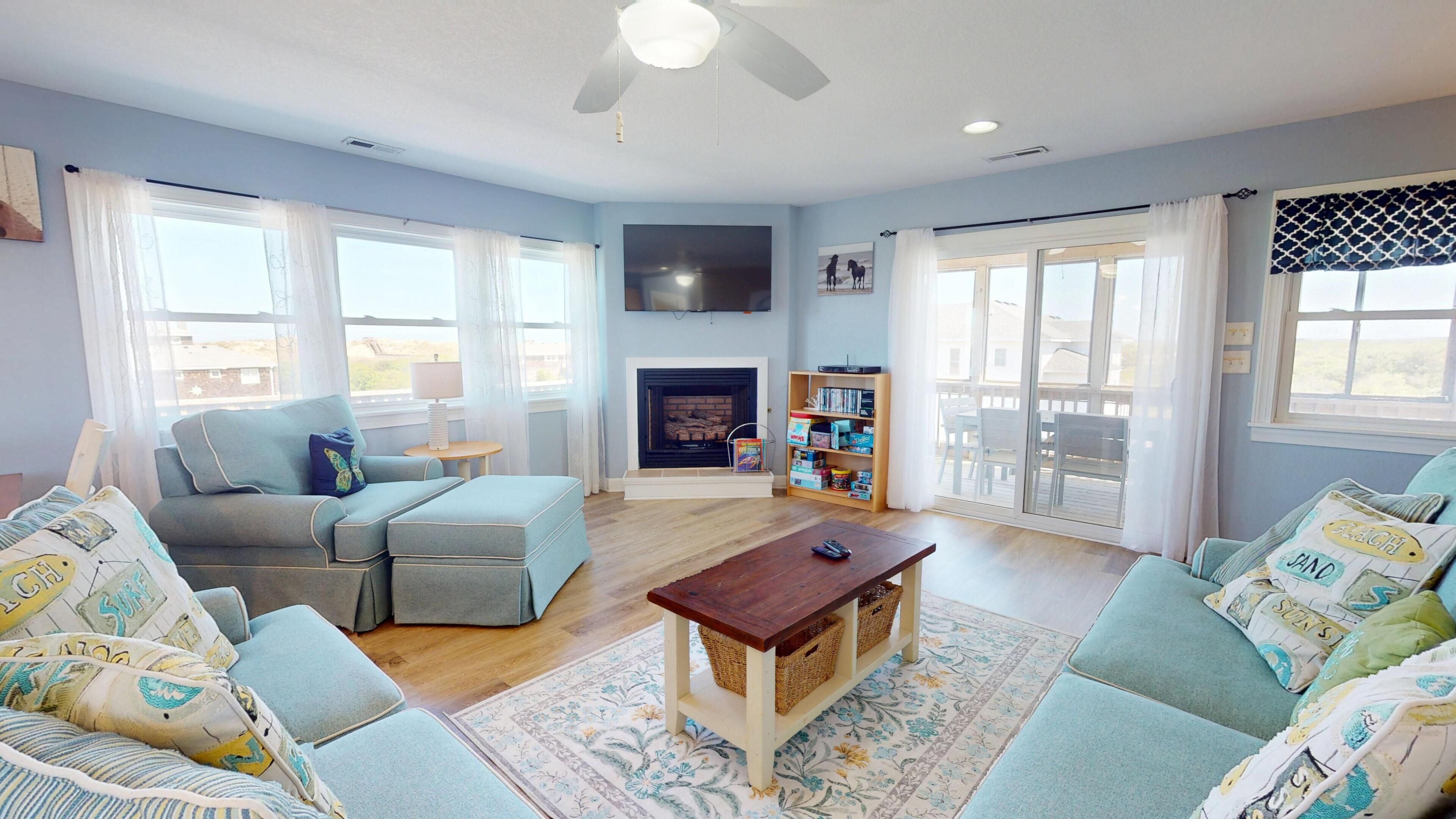 A living room with a fireplace, a sofa set, a coffee table, and a bookshelf.