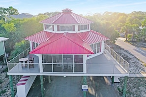 A two-story building with a red roof, a balcony with a table and chairs, and a sign indicating private property. - Unique & spacious w/ Gulf views throughout, easy walk to beach ~ DeLight House (Indian Pass)