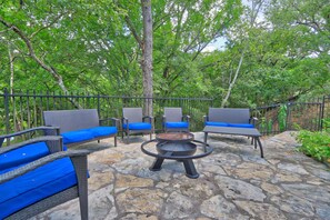 An outdoor patio with wicker furniture and a fire pit.