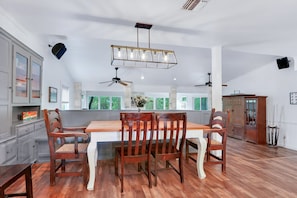 Una cocina amplia con una mesa de comedor de madera, sillas y una lámpara colgante.