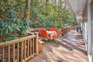 A wooden deck with a table and chairs, surrounded by lush greenery. - Secluded 'Lavinder Laurel Leaf Cottage' Near Creek (Lakemont)
