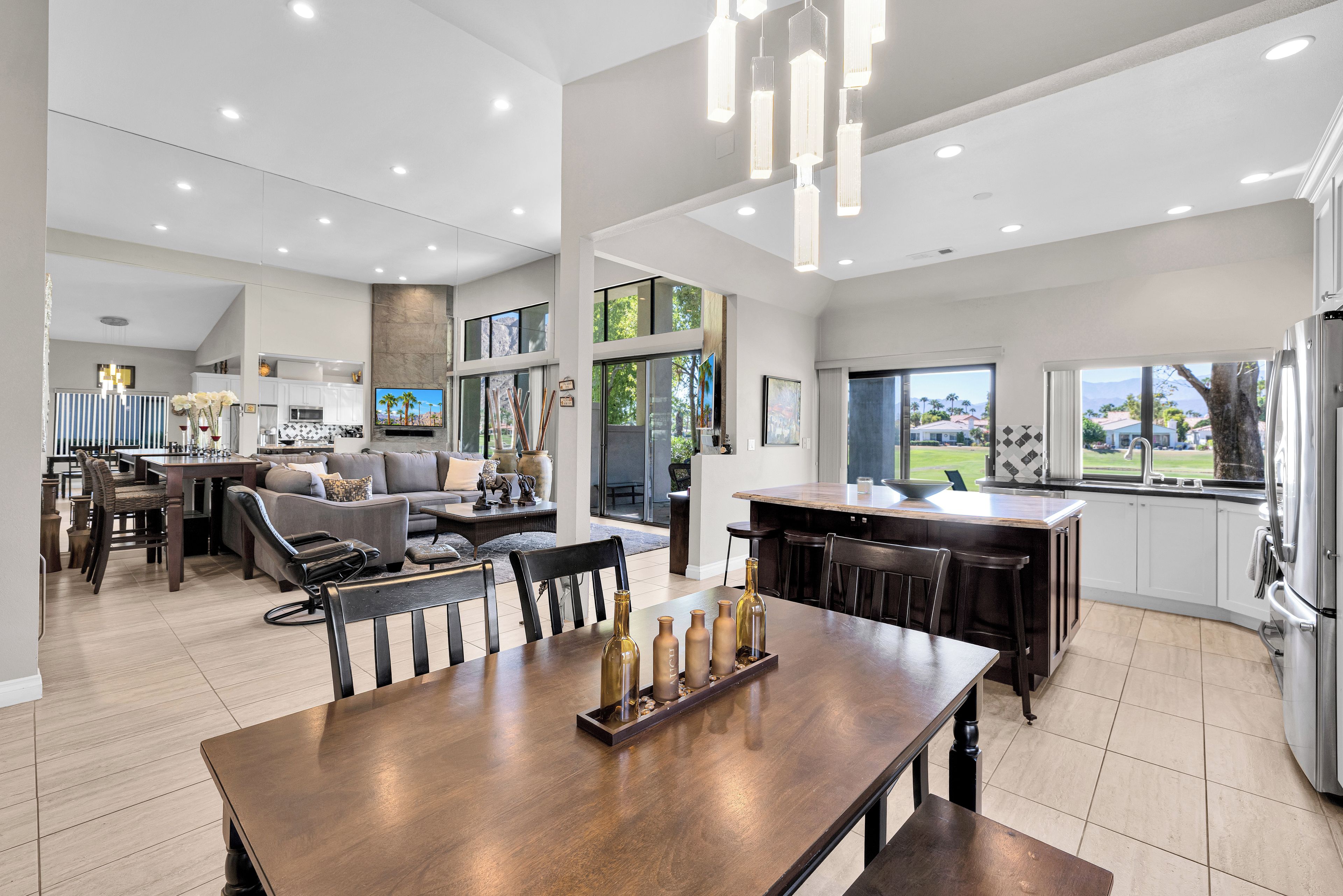 A spacious kitchen with a dining area, large windows, and a view of the outdoors.