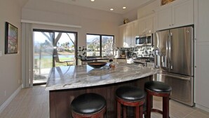 A modern kitchen with a large island, stainless steel appliances, and a view of a pool and mountains. - Delightful 3 Bed Home with Amazing Views LQ171 LIC#110324 (La Quinta)