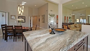 A spacious kitchen with a marble countertop, wooden chairs, and a dining table. - Delightful 3 Bed Home with Amazing Views LQ171 LIC#110324 (La Quinta)