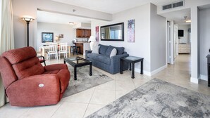 Una sala moderna con un sofá, un sillón reclinable y una mesa de centro.