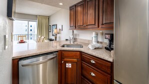 Una cocina moderna con armarios de madera, lavavajillas de acero inoxidable y cafetera integrada.