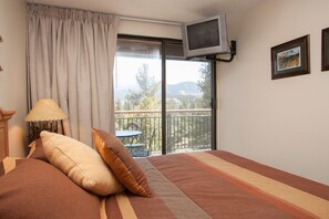 Relax in this inviting room with a large bed, TV, and balcony overlooking the outdoors.