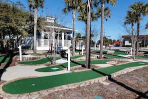 Play a round of golf amidst lush palm trees and a scenic backdrop.