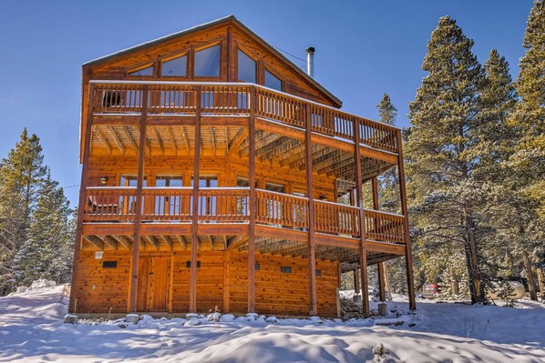 Surrounded by a serene forest, this cabin offers stunning views from its second-floor balcony.