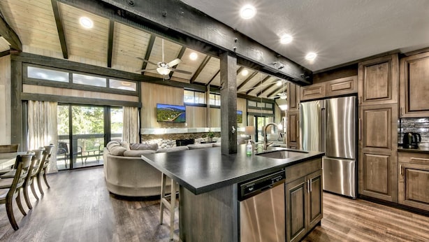 A spacious kitchen with a large island, stainless steel appliances, and a view of a mountainous landscape.