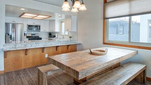 A modern kitchen with a wooden island, built-in appliances, and a large window.