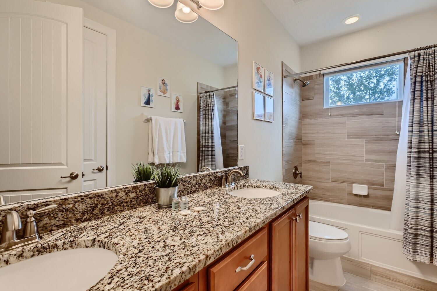 A modern bathroom with two sinks, a large mirror, and a shower area.