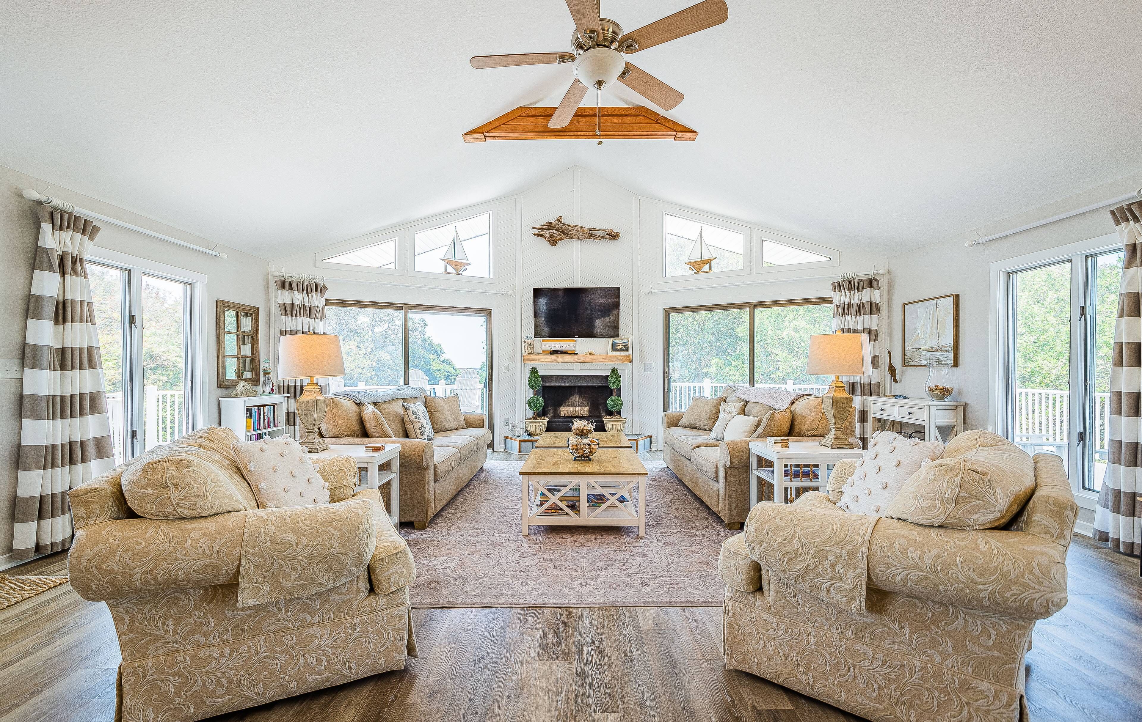 A spacious living room with two sofas, a coffee table, and a fireplace. - Captain's Perch - Duck, Northpoint, 400 Yds to Beach, Pool, Hot Tub, Events, Flex Stays (Duck)