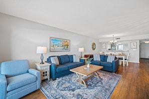 Un salon avec un canapé bleu, une table basse et un tapis.