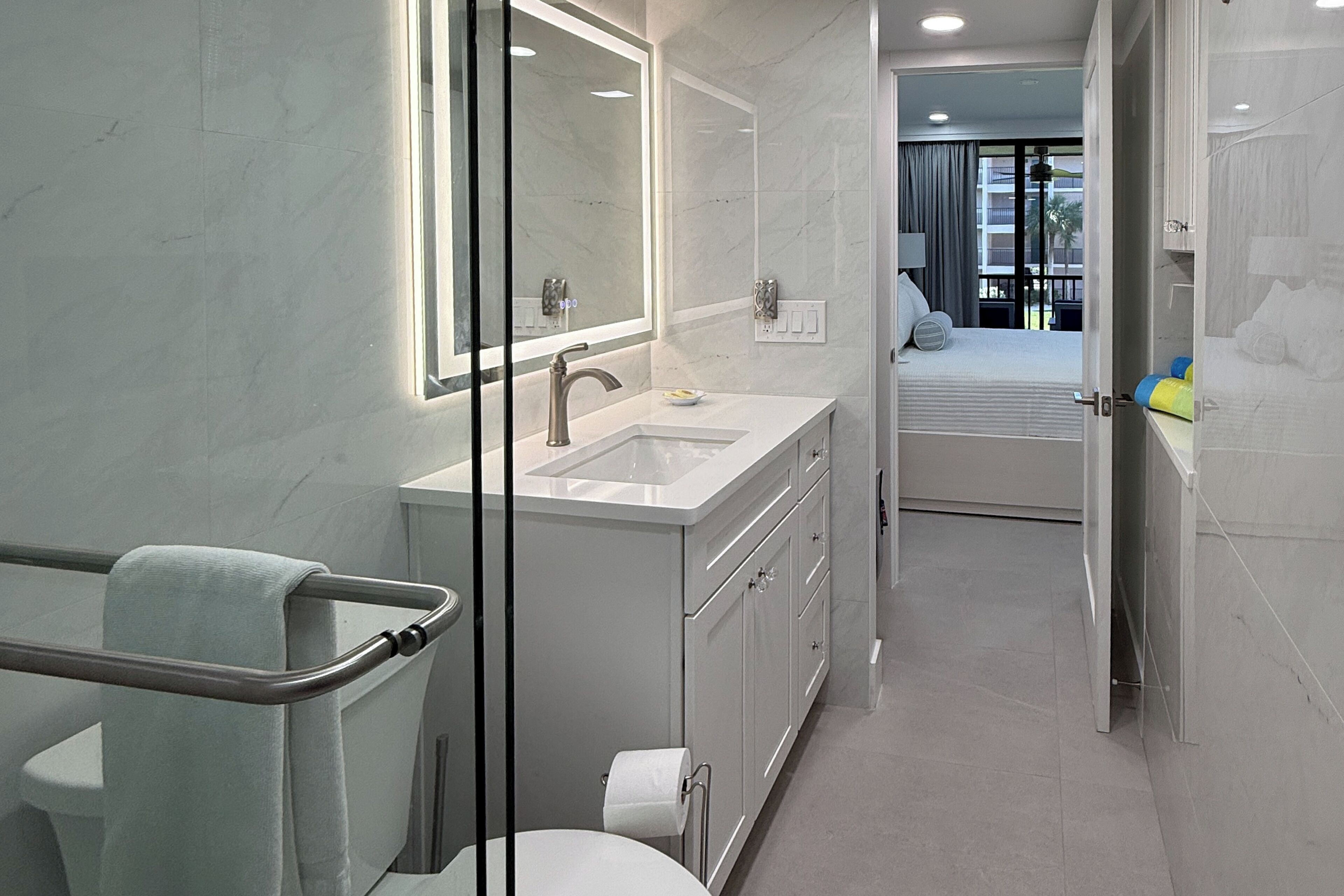 Ein modernes Badezimmer mit Glasabtrennung, Waschbecken und Toilette.