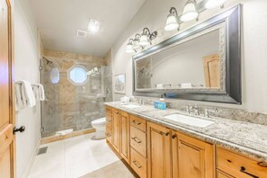 A bathroom with a large mirror, a shower, and a toilet. - Lowell 1175 (Park City)
