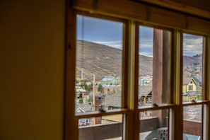 Vista desde una ventana de un pueblo con edificios y una colina.
