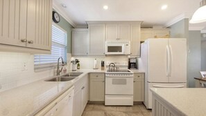 A kitchen with white cabinets, a microwave, a refrigerator, a sink, and a stove. - Condo #311 Extraordinary Siesta Key Beach View at La Siesta- fully renovated!,**20% off July,Aug,Sept,Oct Reservations (Sarasota)