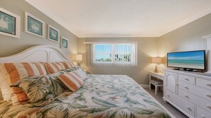 A bedroom with a bed, a television, a dresser, and a window with blinds. - Condo #311 Extraordinary Siesta Key Beach View at La Siesta- fully renovated!,**20% off July,Aug,Sept,Oct Reservations (Sarasota)
