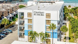 Ein Hotel namens 'Chateau By The Sea' mit Blick auf den Strand und den Ozean.