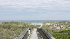 A wooden boardwalk leading to a beach with dunes and a clear sky. - Beautiful oceanfront condo in Ocean Dunes! (Wrightsville Beach)