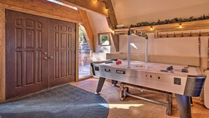 Ein Zimmer mit Holzboden, einer Schiebetür, einem Tisch mit einer Tischtennisplatte und einer Bank.