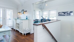Una cocina amplia con armarios blancos, una mesa de comedor de madera y vistas al exterior.