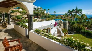 A resort with a pool, outdoor seating, and a view of the ocean. - 2 FREE NIGHTS IN CABO at Casa Maravilla! (Palmilla)