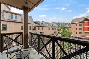 A balcony with a view of a town and mountains.