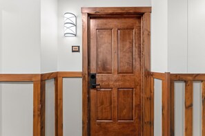 A wooden door with a modern light fixture above it.