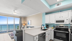 A modern kitchen with white cabinets, a built-in oven, and a dishwasher.