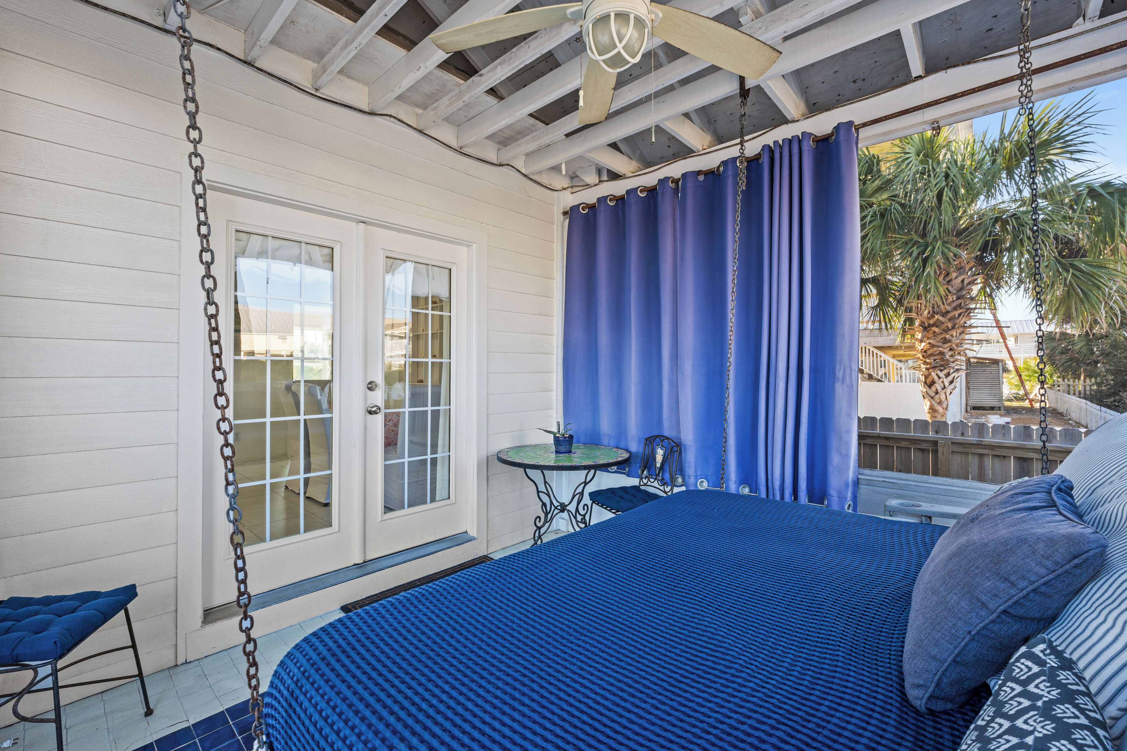 A bedroom with a bed, a small table, and a chair.