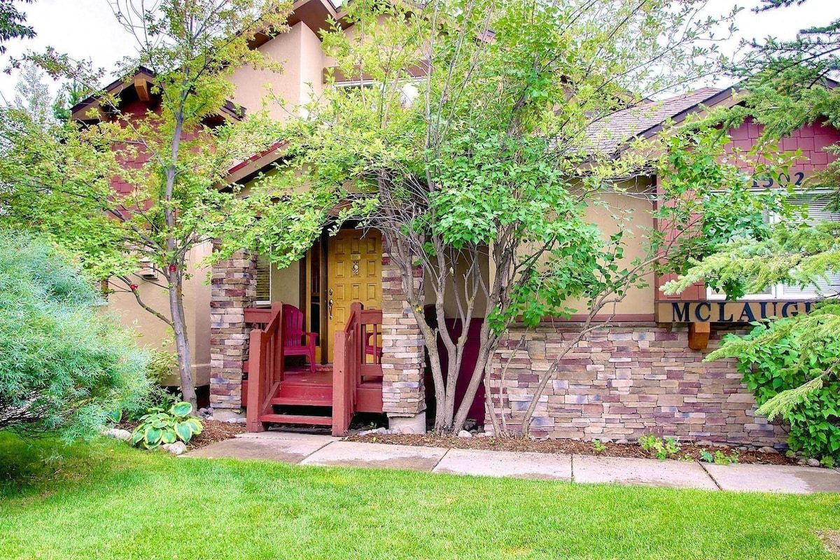 A house with a stone facade, a front porch, and a mailbox.