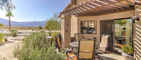 Un patio con mobiliario exterior, una pérgola y vistas a las montañas.