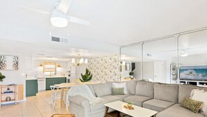 Ein modernes Wohnzimmer mit einer Eckcouch, einem Essbereich und einer Küche.