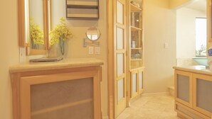 A hallway with wooden cabinets, a mirror, and a vase with yellow flowers.