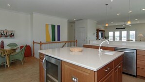 A modern kitchen with a central island, stainless steel appliances, and pendant lighting.