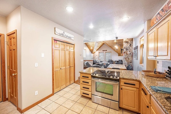 A kitchen with wooden cabinets, a granite countertop, and a built-in oven.